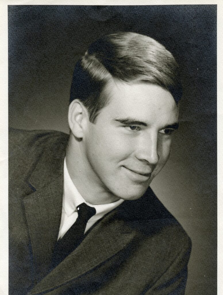 A man in suit and tie smiling for the camera.