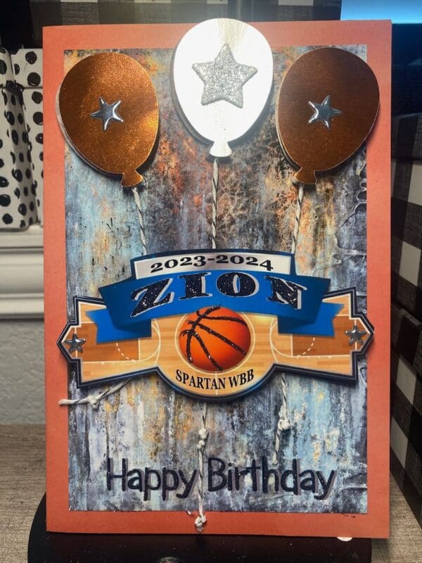 A birthday card with basketball and balloons on it.