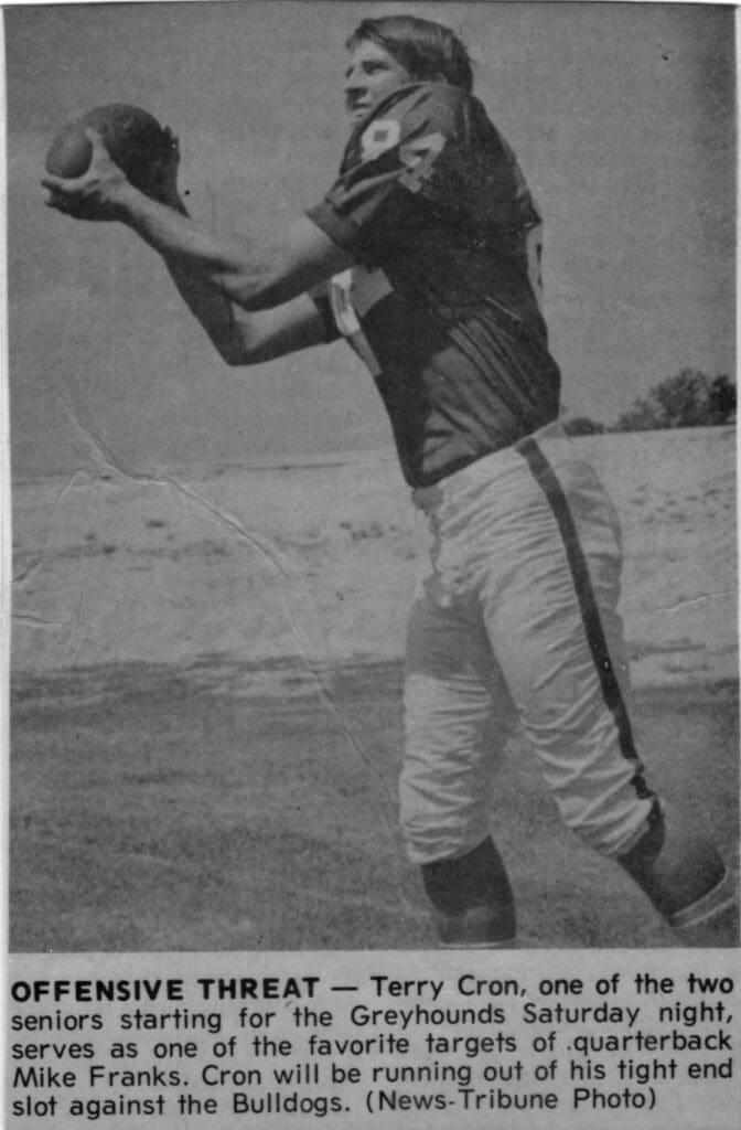 A black and white photo of an older man playing football.